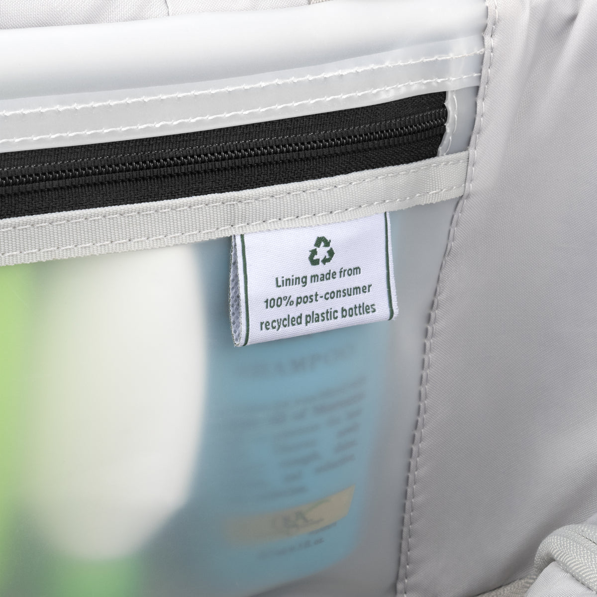 Interior lining tag on a Travelpro suitcase, highlighting construction from 100% post-consumer recycled plastic bottles.