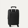 Valise noire à roulettes sur fond gris clair