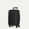 Valise noire à roulettes sur fond gris clair