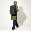 Person wearing a black backpack on a white background
