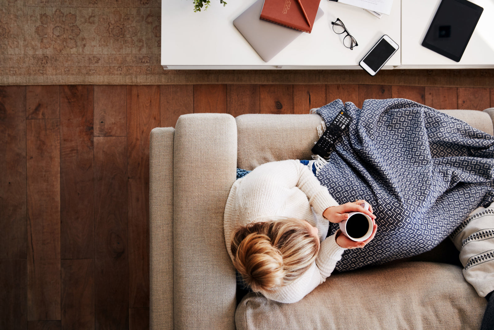 Aerial view of woman drinking coffee on a couch