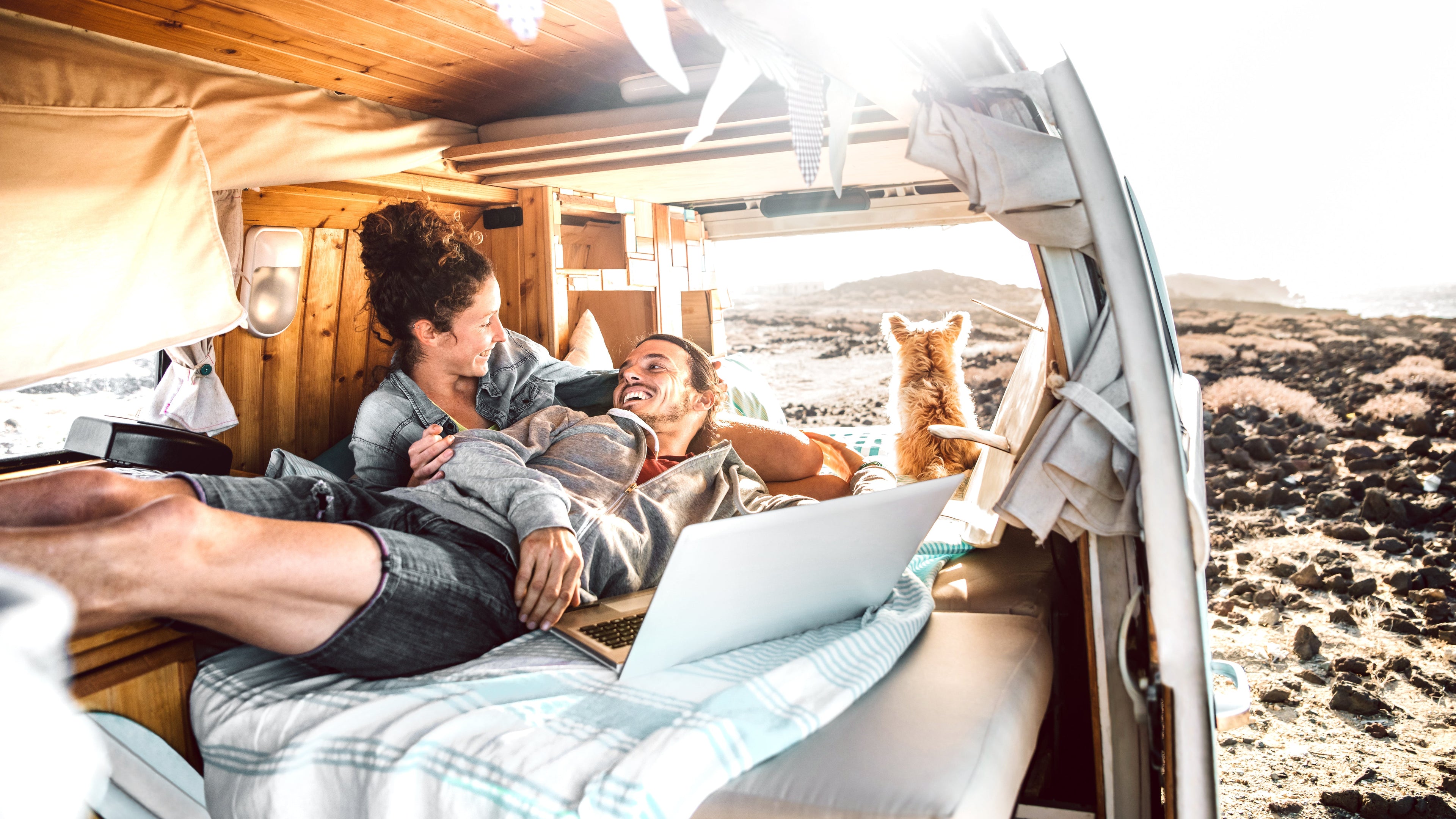 Couple working from the back of a van on the beach