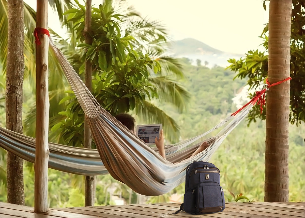 Person laying on a hammock while using tablet