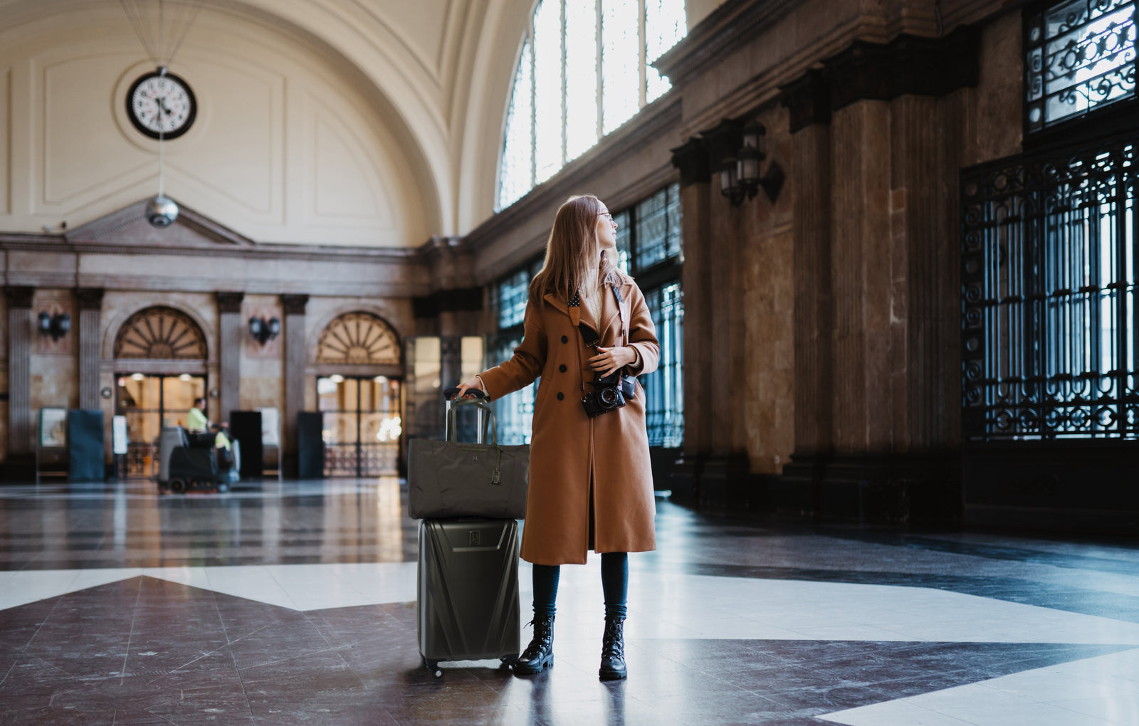 Femme debout dans une gare, regardant au loin
