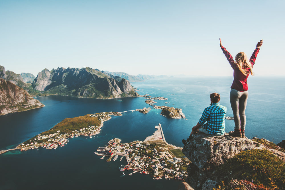 couple celebrating on a cliff overlooking the ocean
