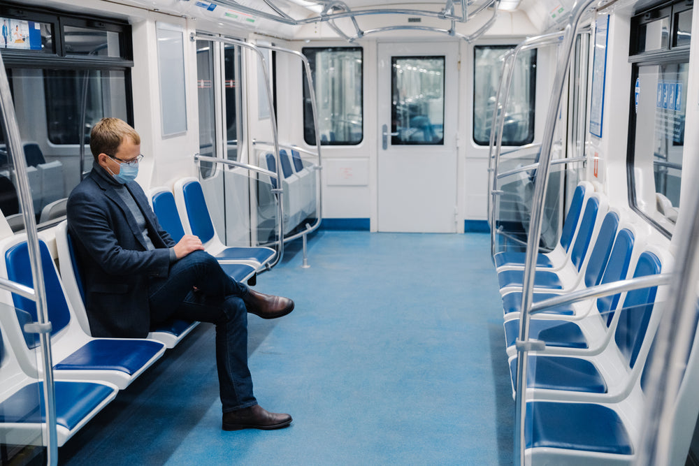 man wearing mask sitting on train