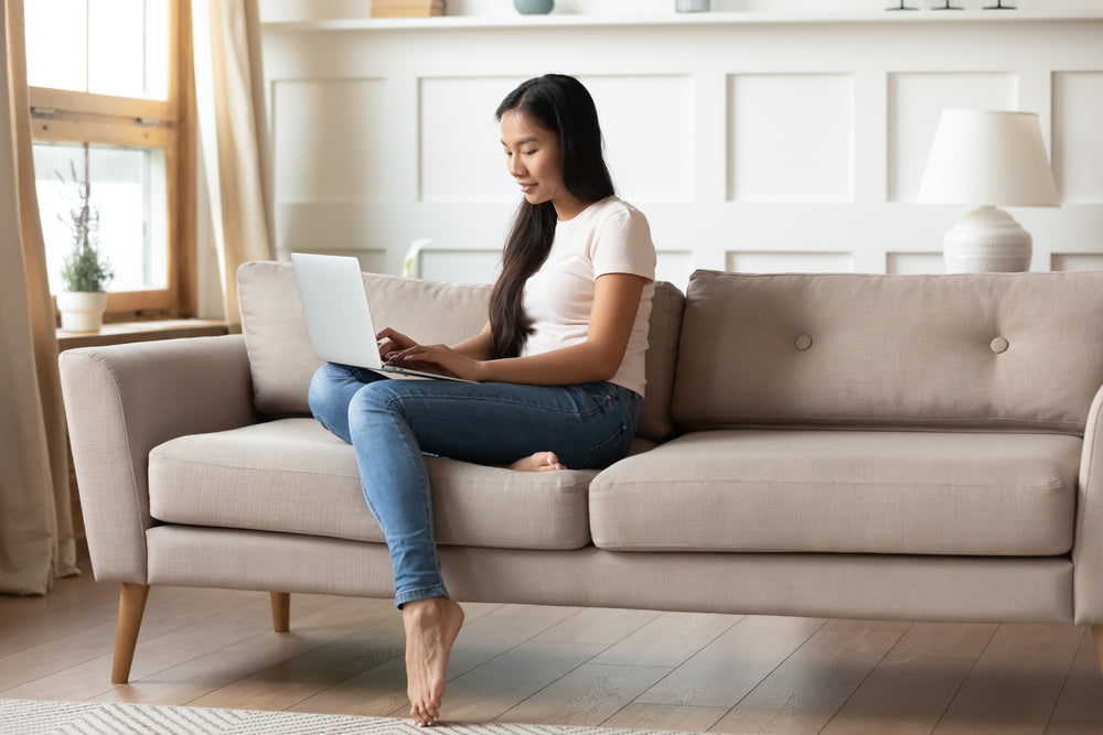 Girl sitting on couch using a laptop