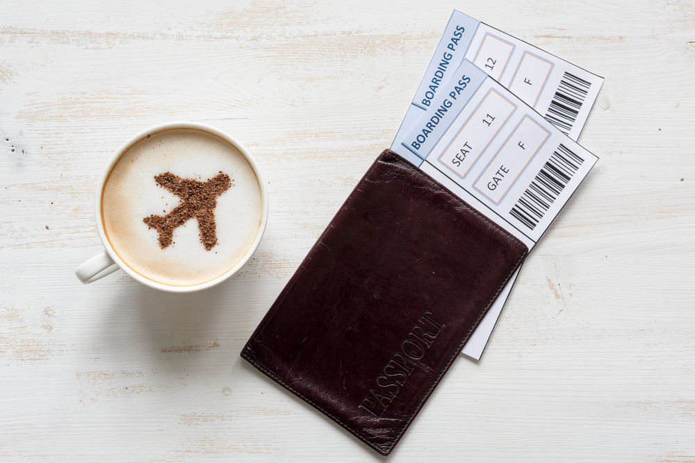 Cup of coffee, passports and no name boarding passes. Airplane made of cinnamon in coffee. Traveling concept. Cappuccino in airport