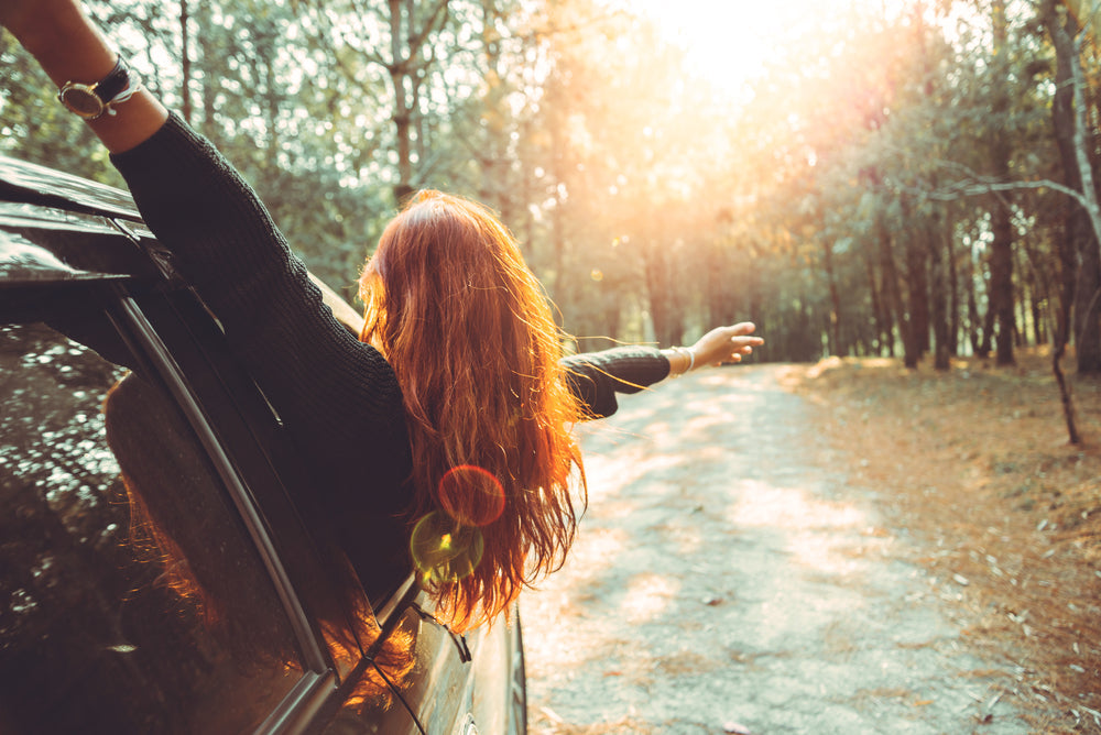 woman feeling free. Woman hanging out a car window
