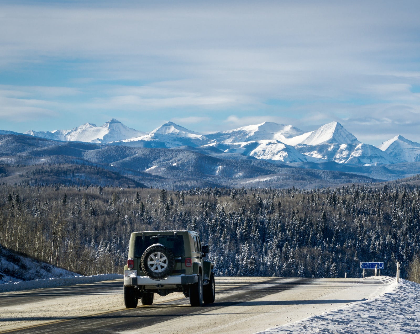 Jeep on the road, surrounded by mountains