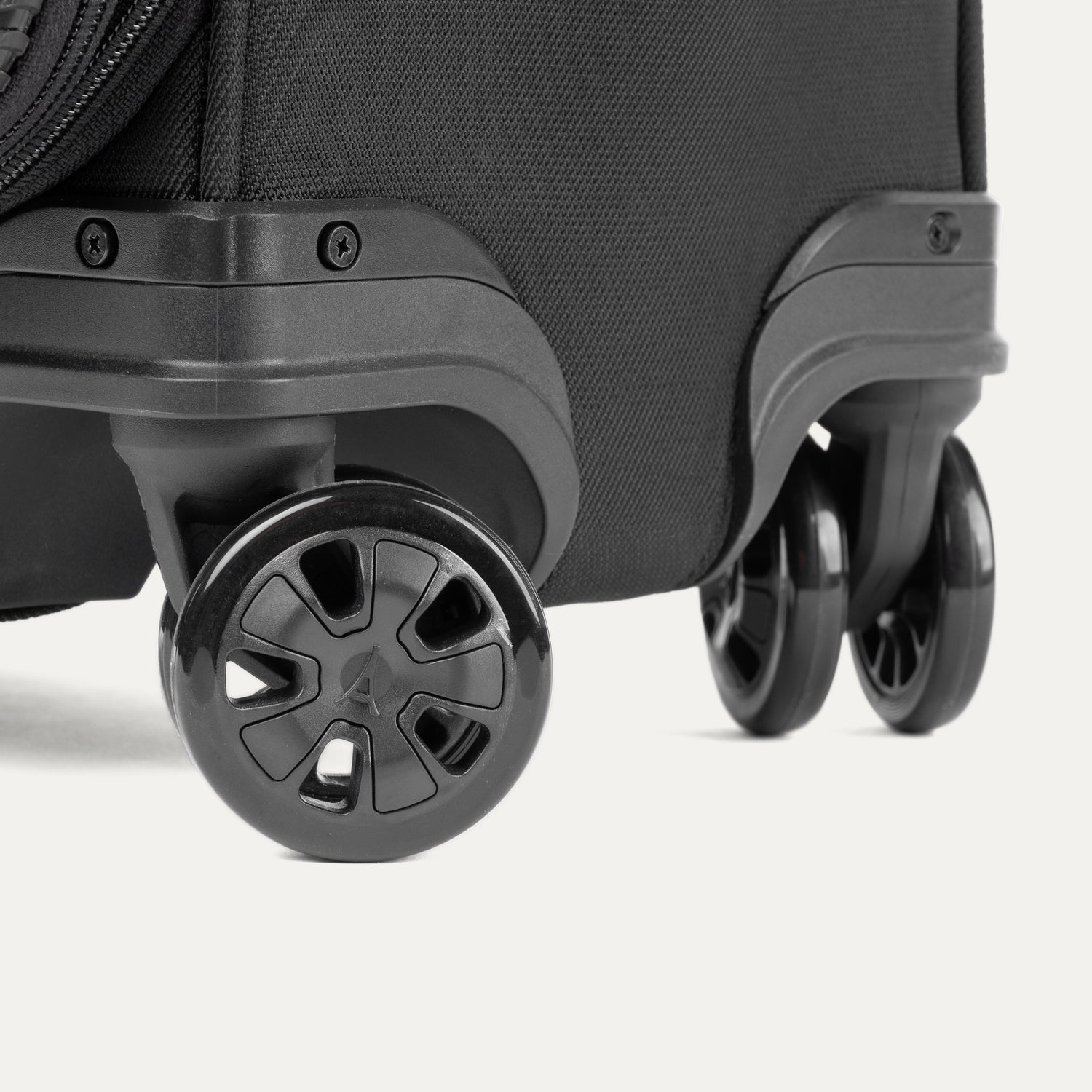 Gros plan sur la valise Classic Travelpro Crew Classic Spinner en noir, mettant en avant ses roulettes pivotantes à 360°.
