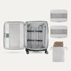 Interior of Travelpro Versapack Checked Luggage in Desert Sage Green, showing packing cubes, laundry bag, and adjustable hold-down straps.