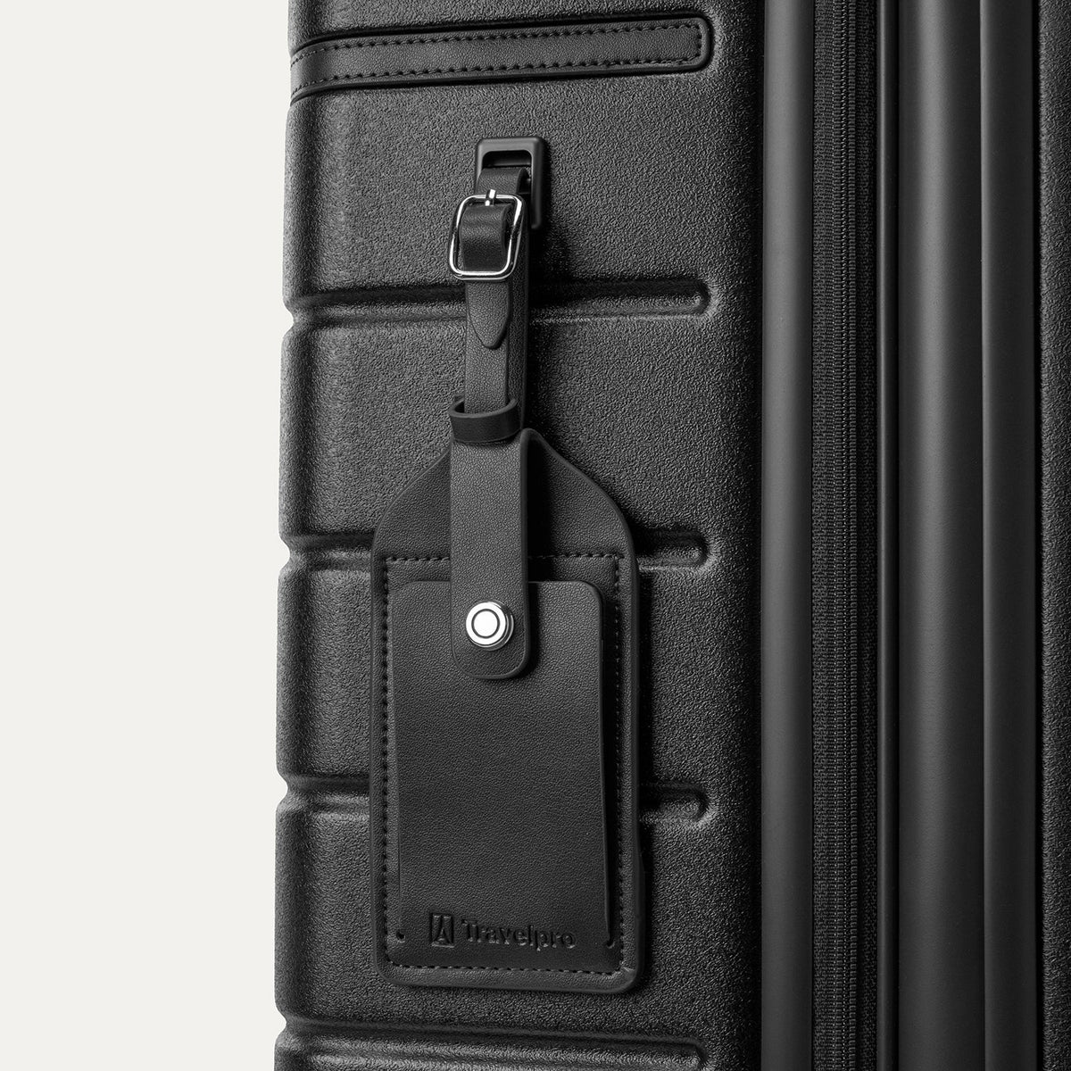 Close-up of the full-grain leather luggage tag on the Travelpro Platinum Reserve Compact Carry-On Hardside Spinner in Black Dust