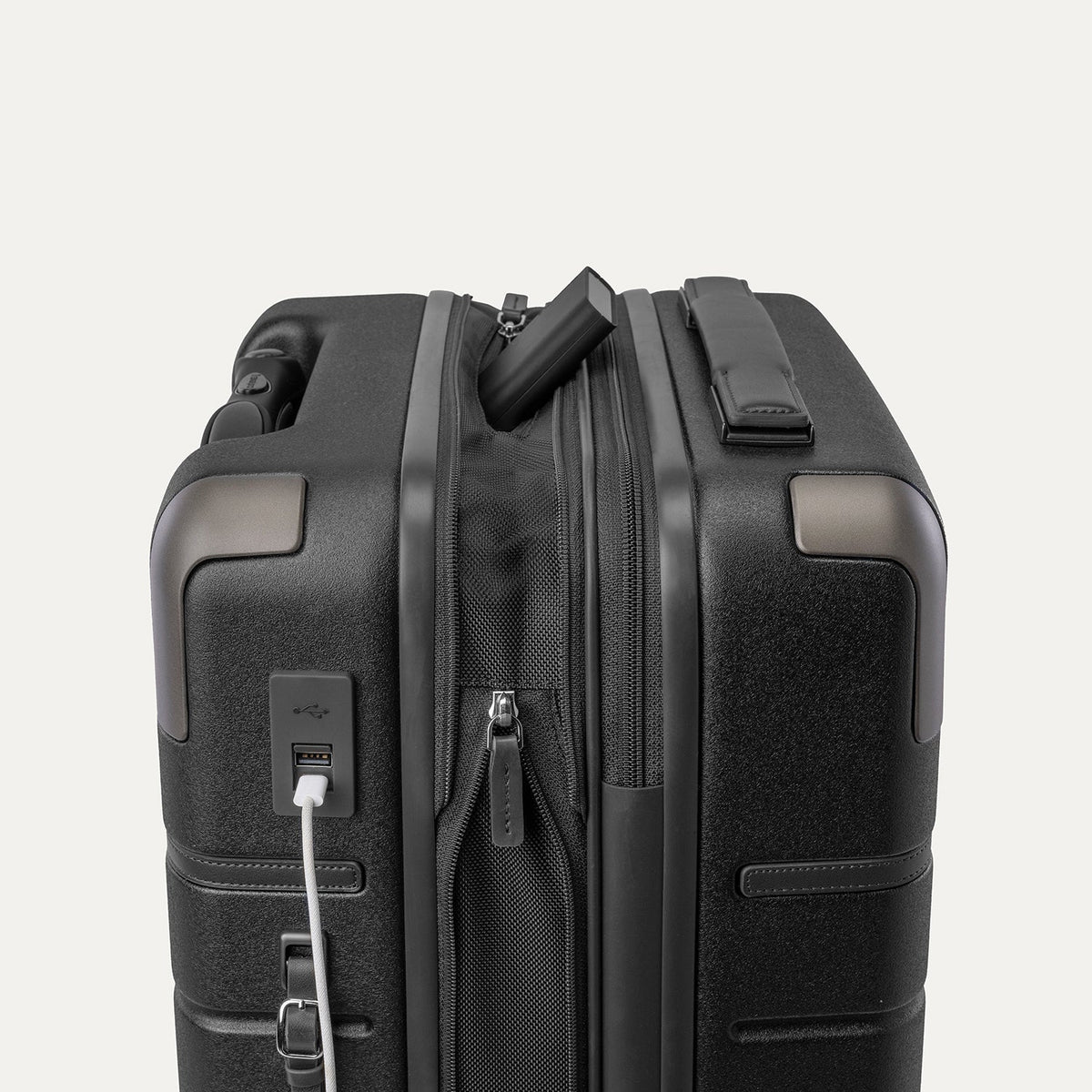 Charging cable plugged into the external USB port on the Travelpro Platinum Reserve Compact Carry-On Hardside Spinner in Black Dust