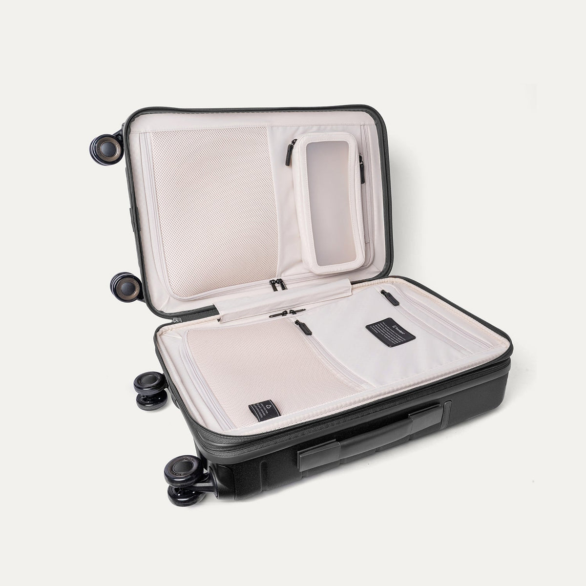 Open interior of the Travelpro Platinum Reserve Compact Carry-On Hardside Spinner in Black Dust showing the zippered divider panel and dedicated pockets