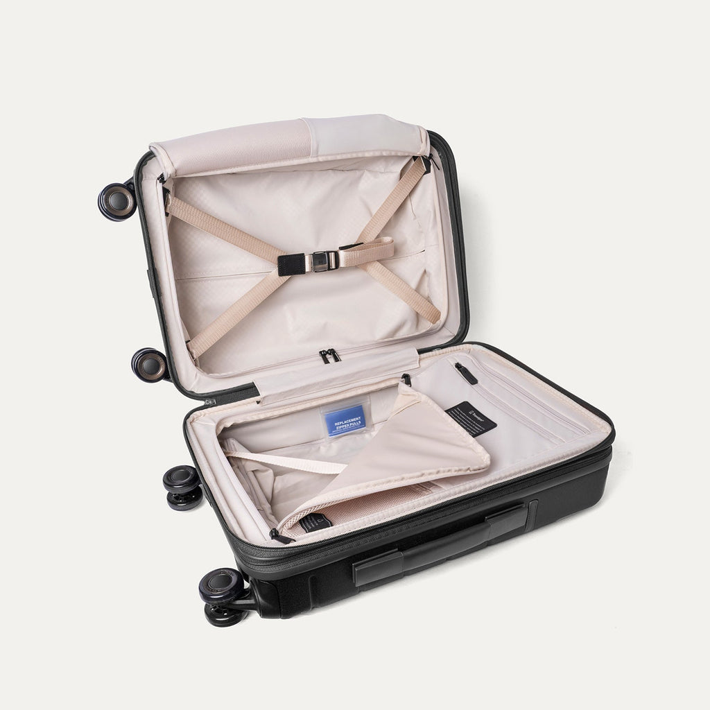 Open interior of the Travelpro Platinum Reserve Compact Carry-On Hardside Spinner in Black Dust with hold-down straps