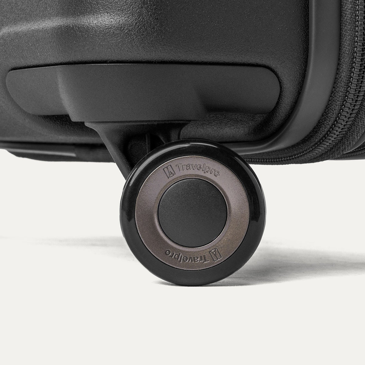 Close-up of a MagnaTrac self-aligning spinner wheel on the Travelpro Platinum Reserve Compact Carry-On Hardside Spinner in Black Dust