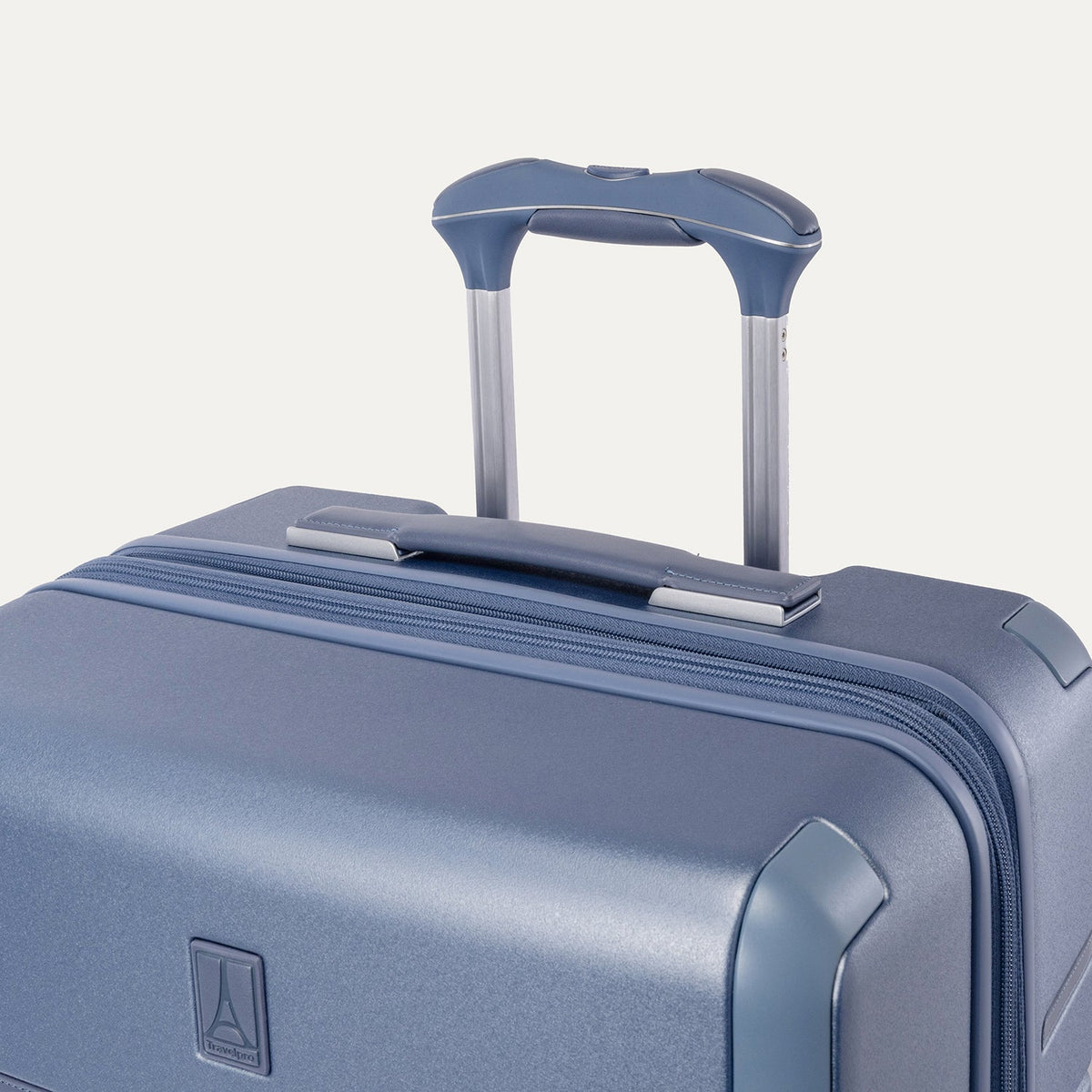 Close-up of the leather-wrapped top handle and PowerScope Lite extension handle on the Travelpro Platinum Reserve Compact Carry-On Hardside Spinner in Steel Blue
