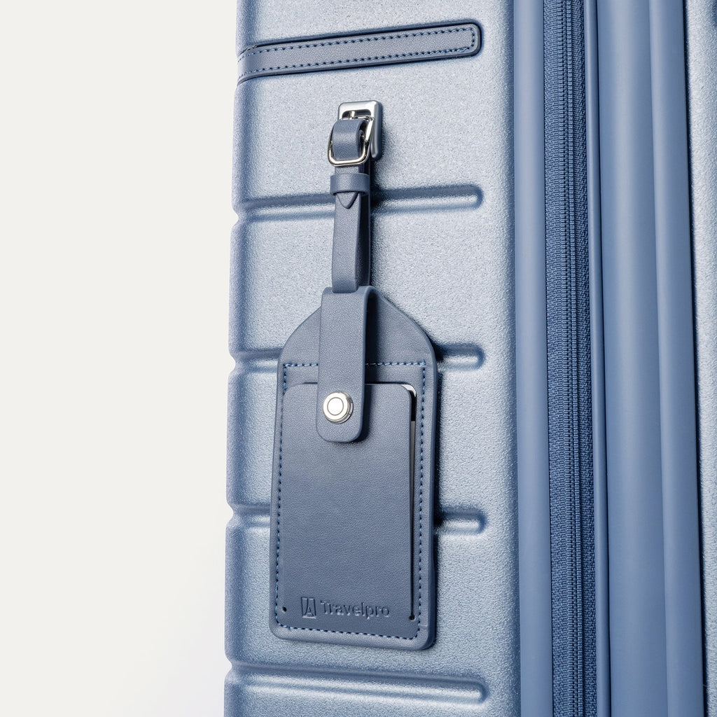 Close-up of the full-grain leather luggage tag on the Travelpro Platinum Reserve Compact Carry-On Hardside Spinner in Steel Blue