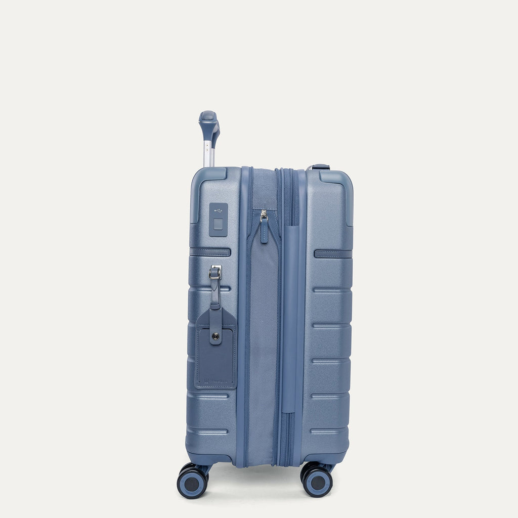 Side profile of the Travelpro Platinum Reserve Compact Carry-On Hardside Spinner in Steel Blue, expanded for extra packing space