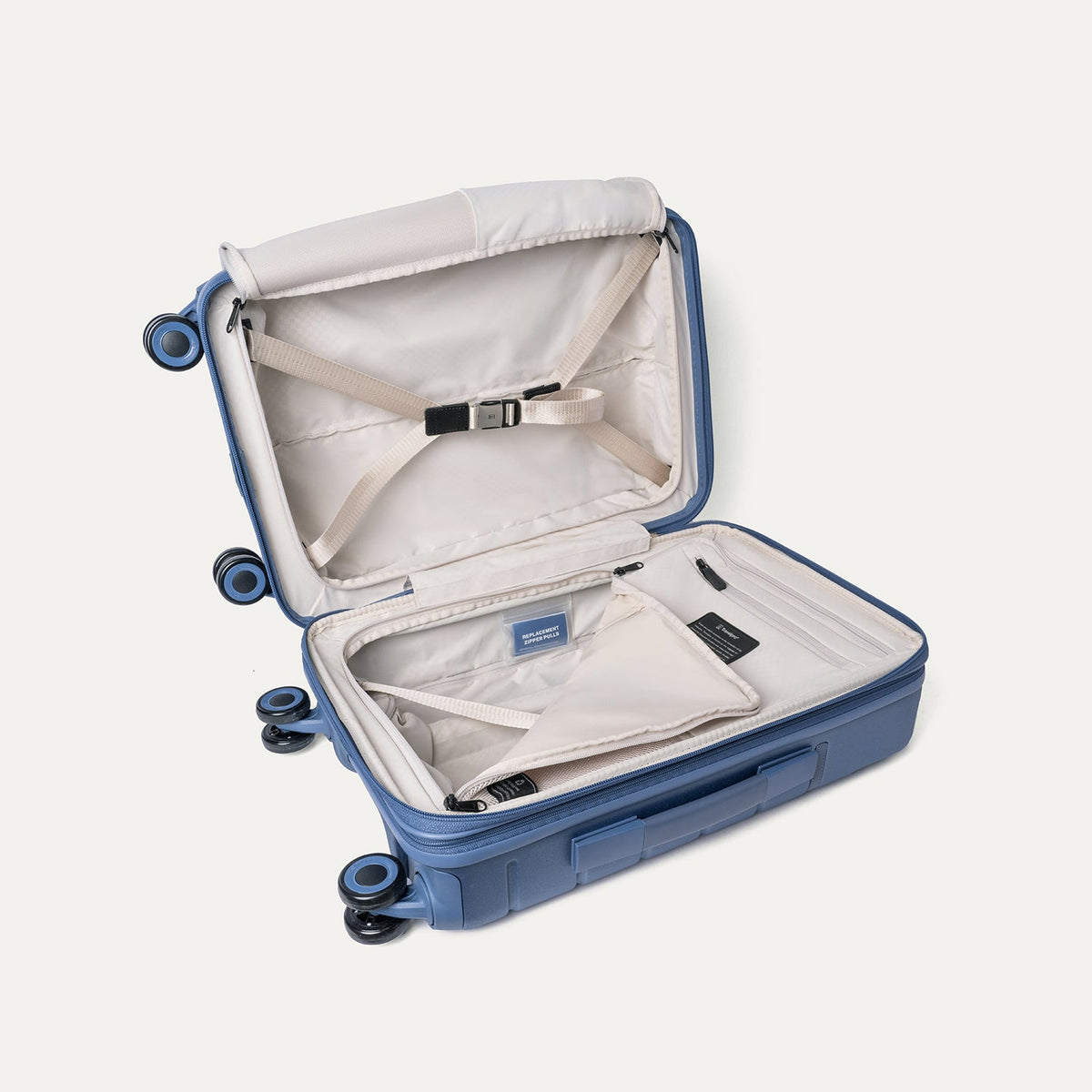 Open interior of the Travelpro Platinum Reserve Compact Carry-On Hardside Spinner in Steel Blue with hold-down straps