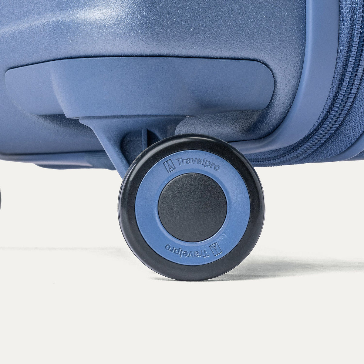 Close-up of a MagnaTrac self-aligning spinner wheel on the Travelpro Platinum Reserve Compact Carry-On Hardside Spinner in Steel Blue