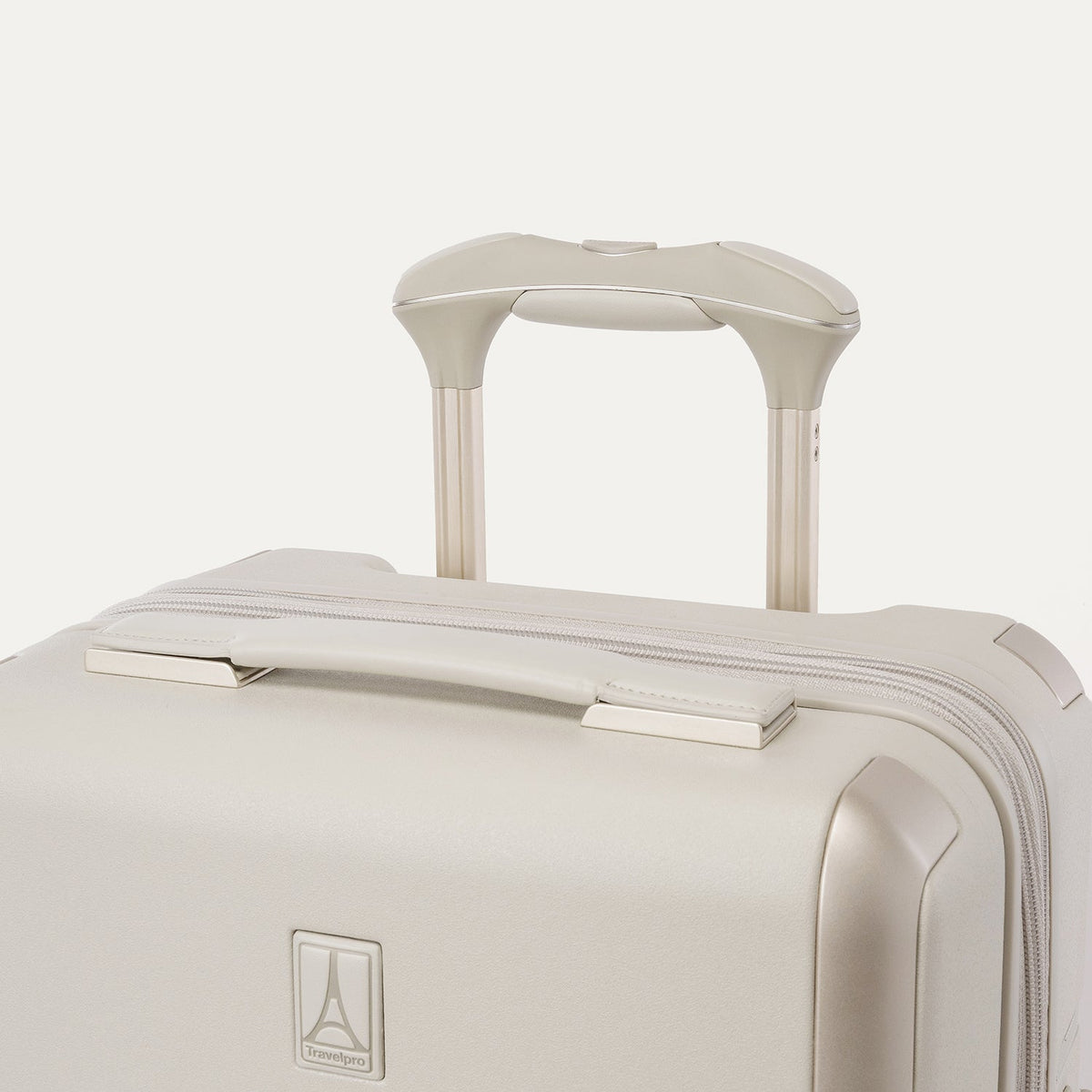 Close-up of the leather-wrapped top handle and PowerScope Lite extension handle on the Travelpro Platinum Reserve Compact Carry-On Hardside Spinner in Sandstone