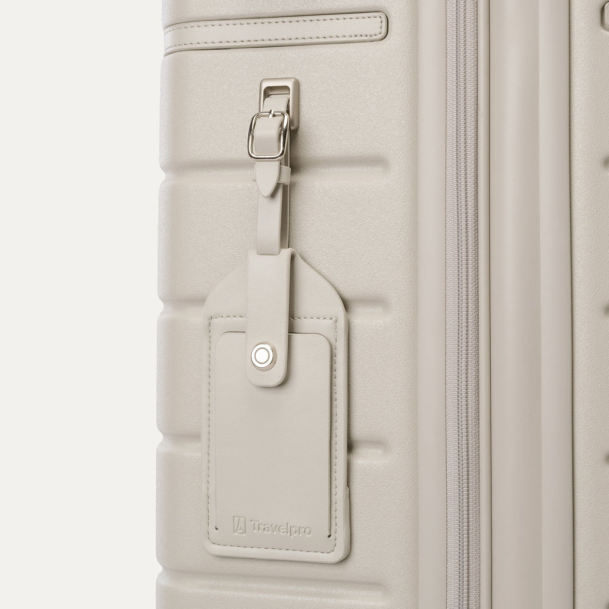 Close-up of the full-grain leather luggage tag on the Travelpro Platinum Reserve Compact Carry-On Hardside Spinner in Sandstone