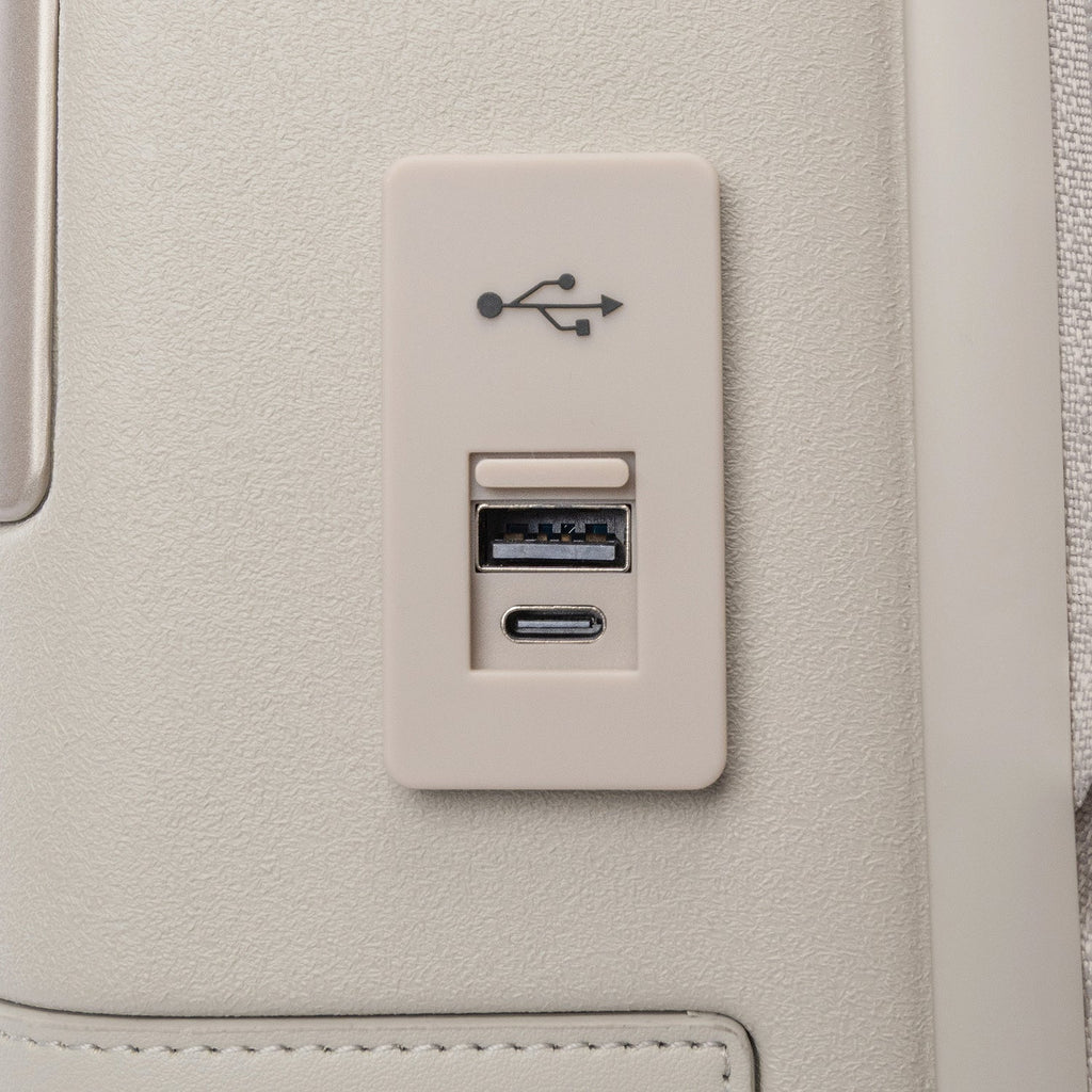 Close-up of the external USB-A and USB-C charging ports on the Travelpro Platinum Reserve Compact Carry-On Hardside Spinner in Sandstone