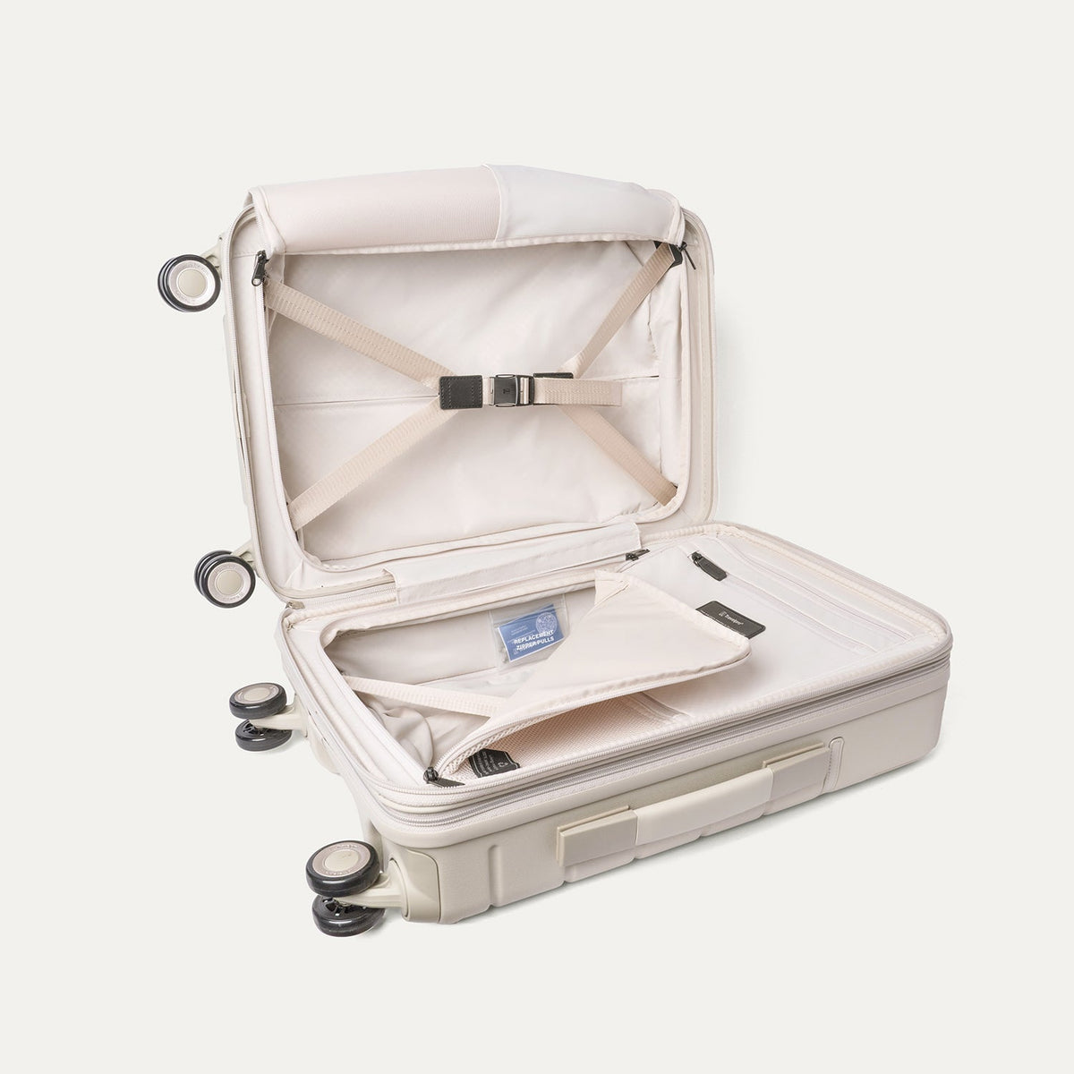 Open interior of the Travelpro Platinum Reserve Compact Carry-On Hardside Spinner in Sandstone with hold-down straps