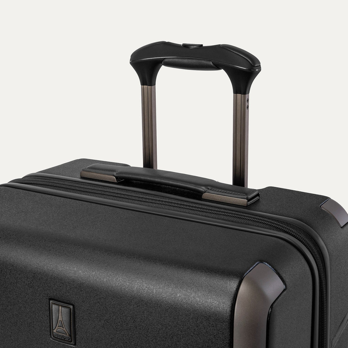 Close-up of the leather-wrapped top handle and PowerScope Lite extension handle on the Travelpro Platinum Reserve Medium Check-In Hardside Spinner in Black Dust