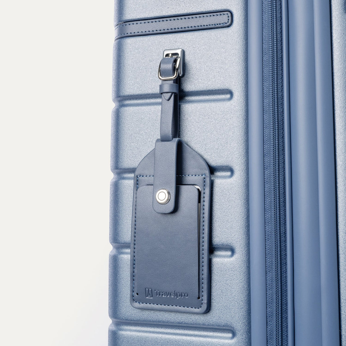 Close-up of the full-grain leather luggage tag on the Travelpro Platinum Reserve Medium Check-In Hardside Spinner in Steel Blue