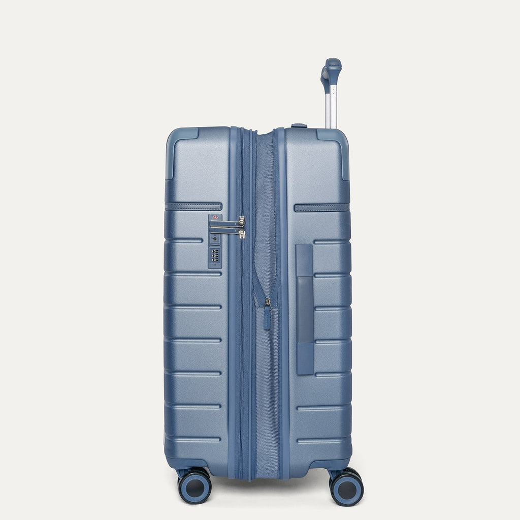 Side profile of the Travelpro Platinum Reserve Medium Check-In Hardside Spinner in Steel Blue, expanded for extra packing space