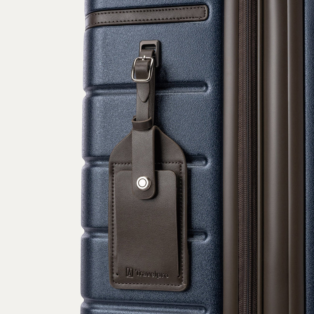 Close-up of the full-grain leather luggage tag on the Travelpro Platinum Reserve Medium Check-In Hardside Spinner in Midnight Trail