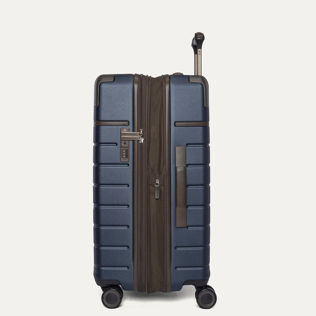 Side profile of the Travelpro Platinum Reserve Medium Check-In Hardside Spinner in Midnight Trail, expanded for extra packing space