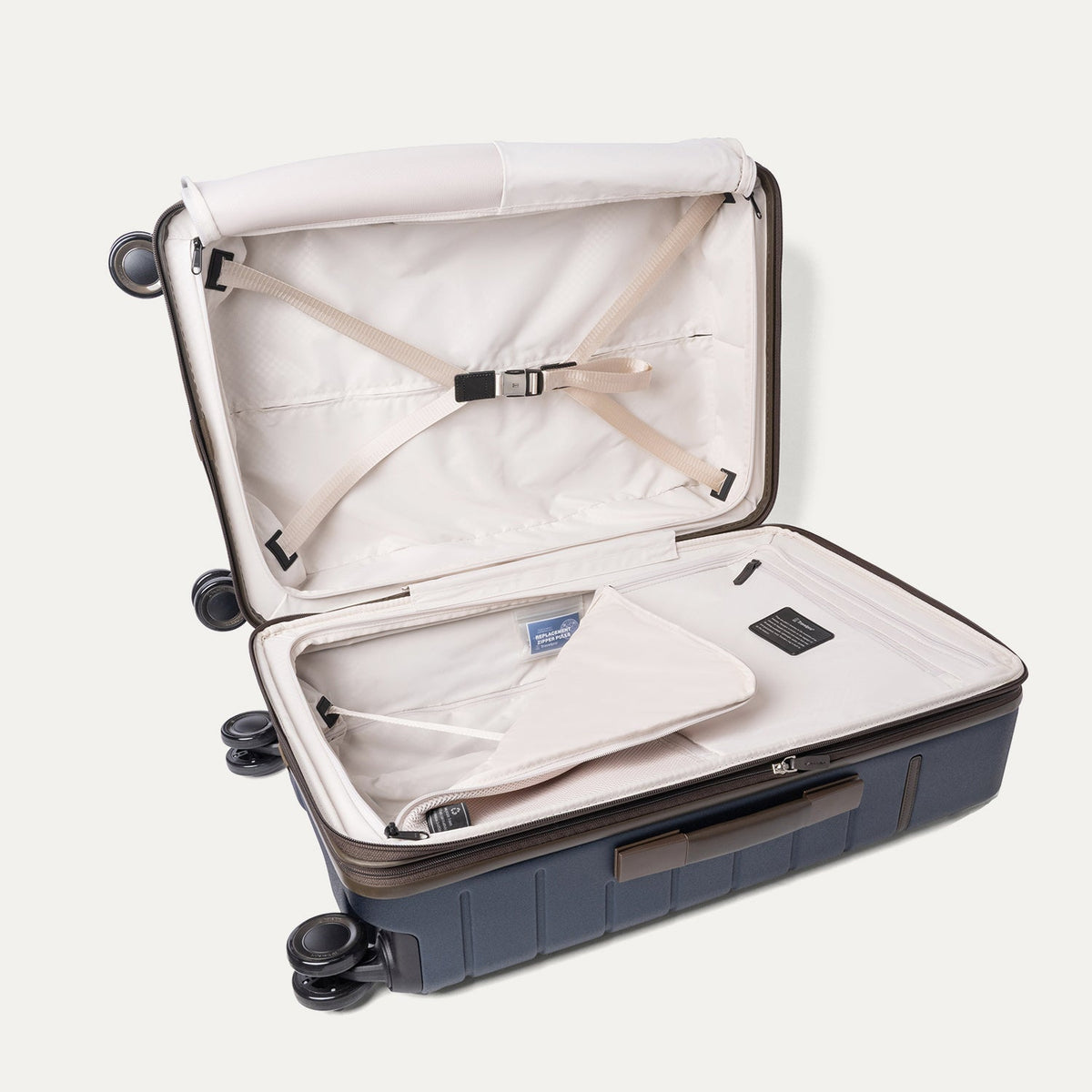 Open interior of the Travelpro Platinum Reserve Medium Check-In Hardside Spinner in Midnight Trail with hold-down straps
