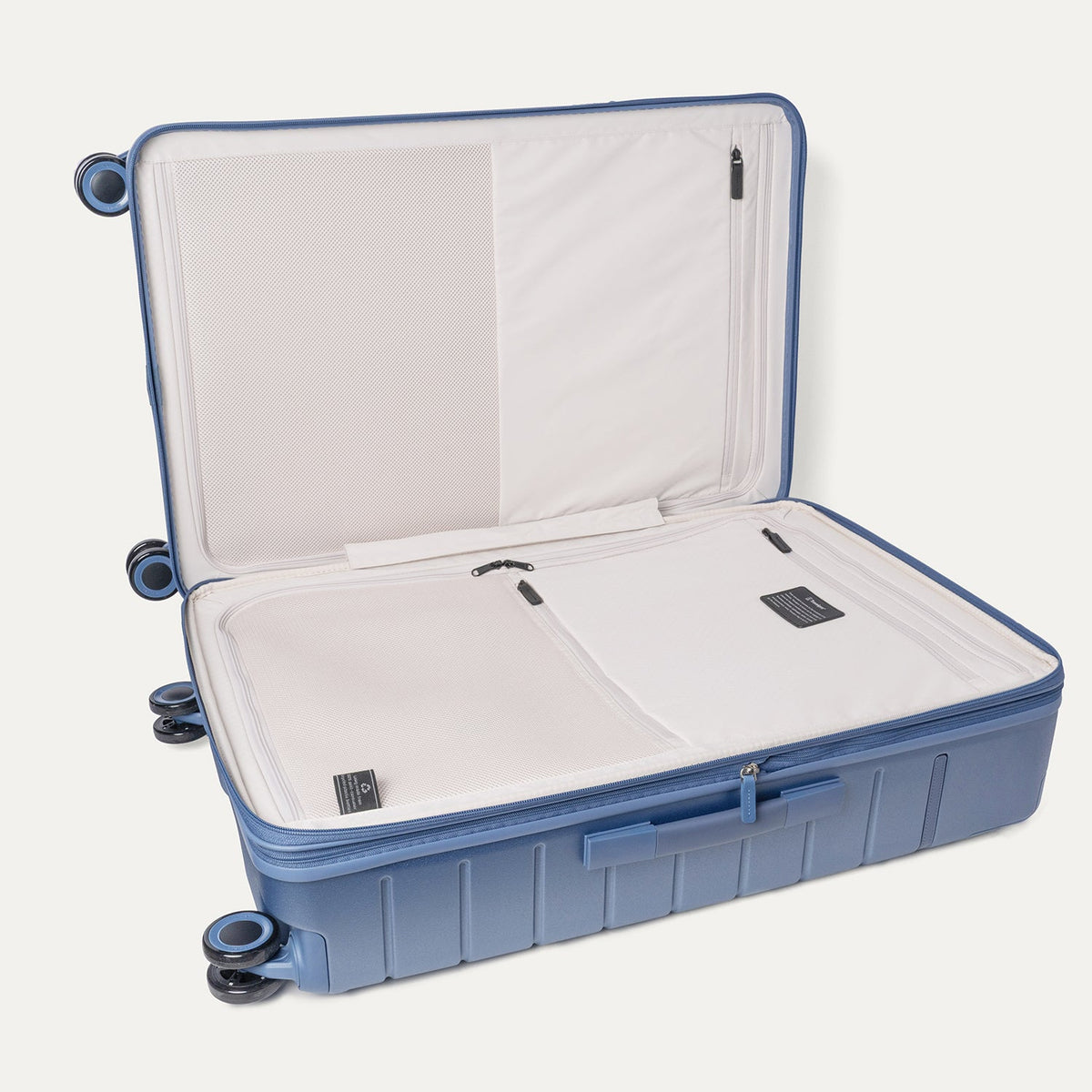 Open interior of the Travelpro Platinum Reserve Large Check-In Hardside Spinner in Steel Blue showing the zippered divider panel and dedicated pockets
