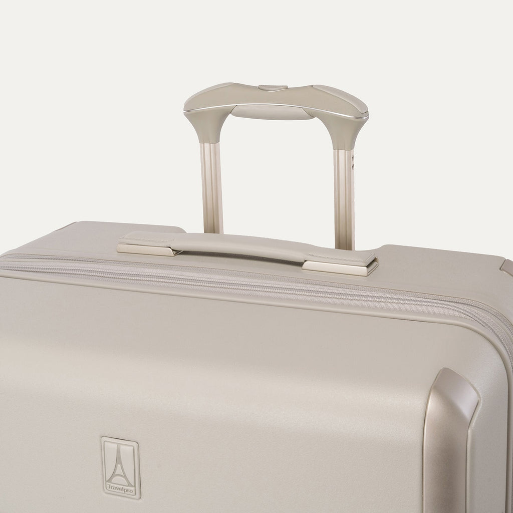 Close-up of the leather-wrapped top handle and PowerScope Lite extension handle on the Travelpro Platinum Reserve Large Check-In Hardside Spinner in Sandstone