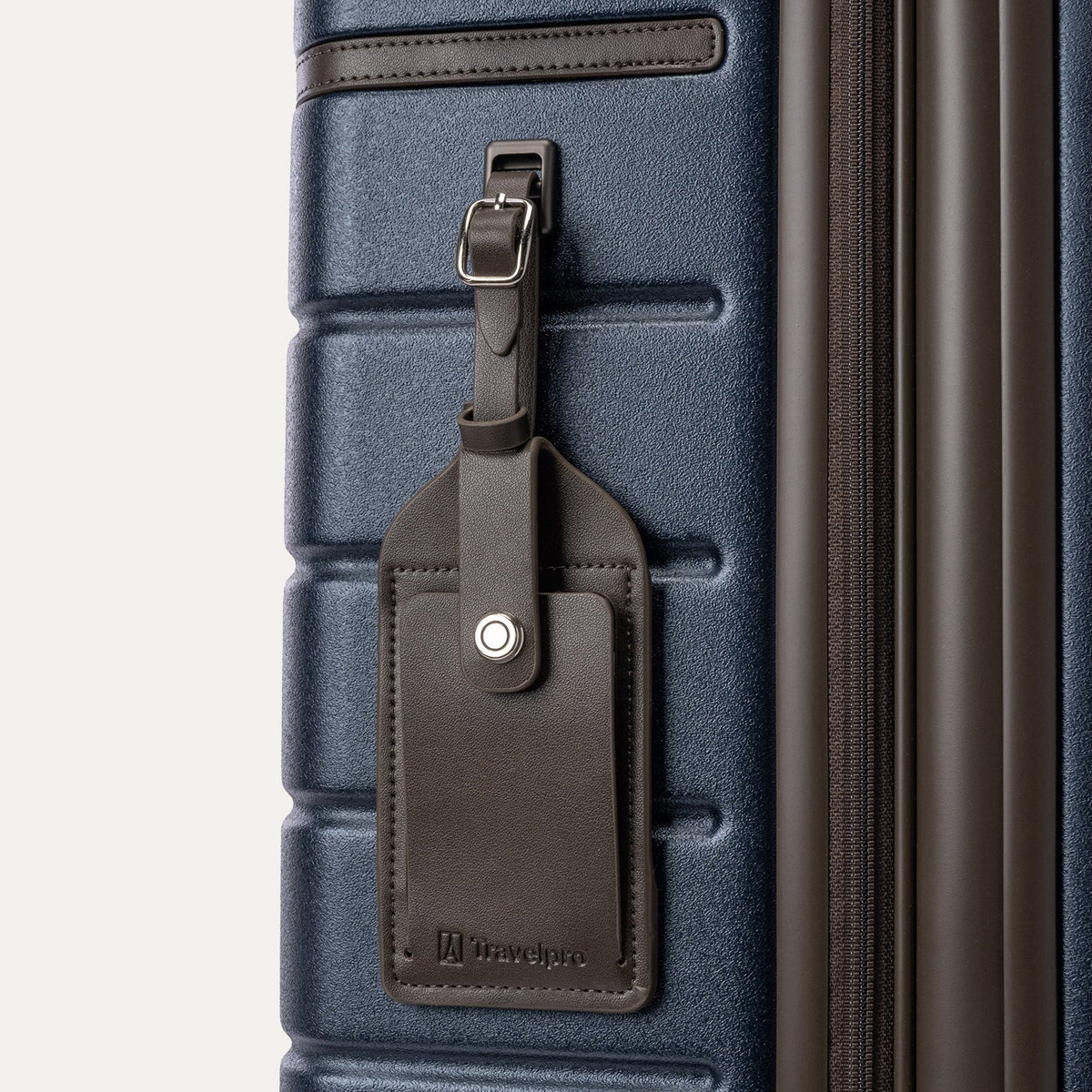 Close-up of the full-grain leather luggage tag on the Travelpro Platinum Reserve Large Check-In Hardside Spinner in Midnight Trail