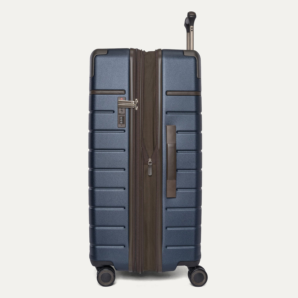 Side profile of the Travelpro Platinum Reserve Large Check-In Hardside Spinner in Midnight Trail, expanded for extra packing space