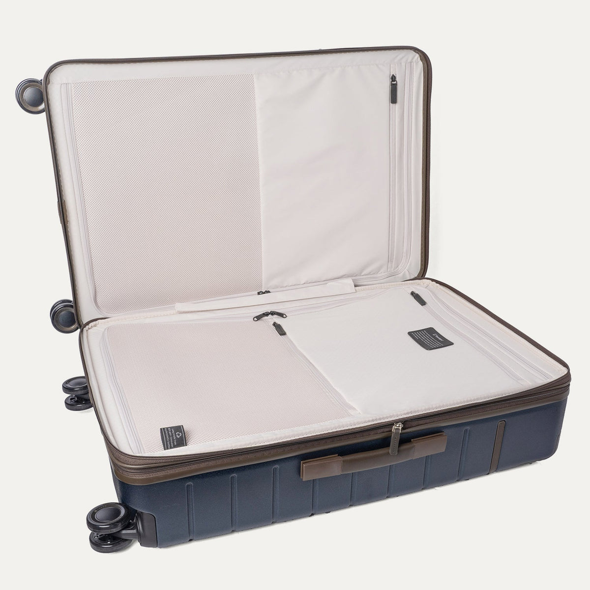 Open interior of the Travelpro Platinum Reserve Large Check-In Hardside Spinner in Midnight Trail showing the zippered divider panel and dedicated pockets