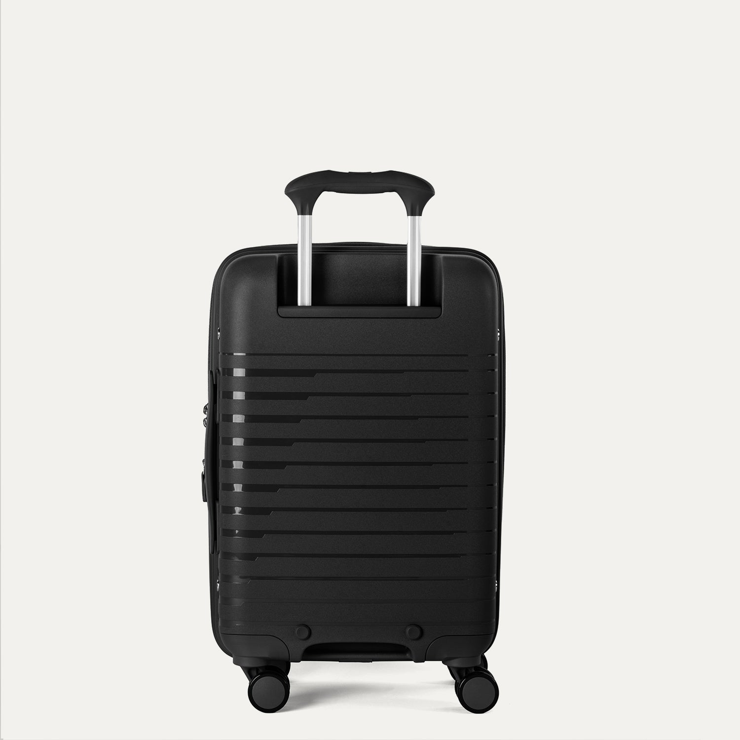 Valise noire à roulettes sur fond gris clair