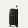 Valise noire à roulettes sur fond gris clair