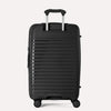 Valise noire à texture nervurée sur fond gris clair