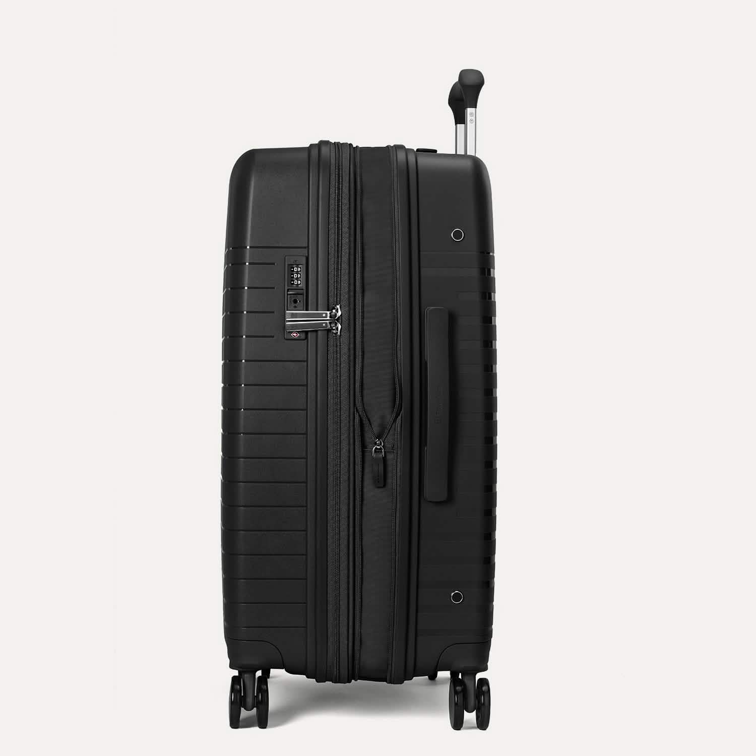Valise noire à roulettes sur fond gris clair