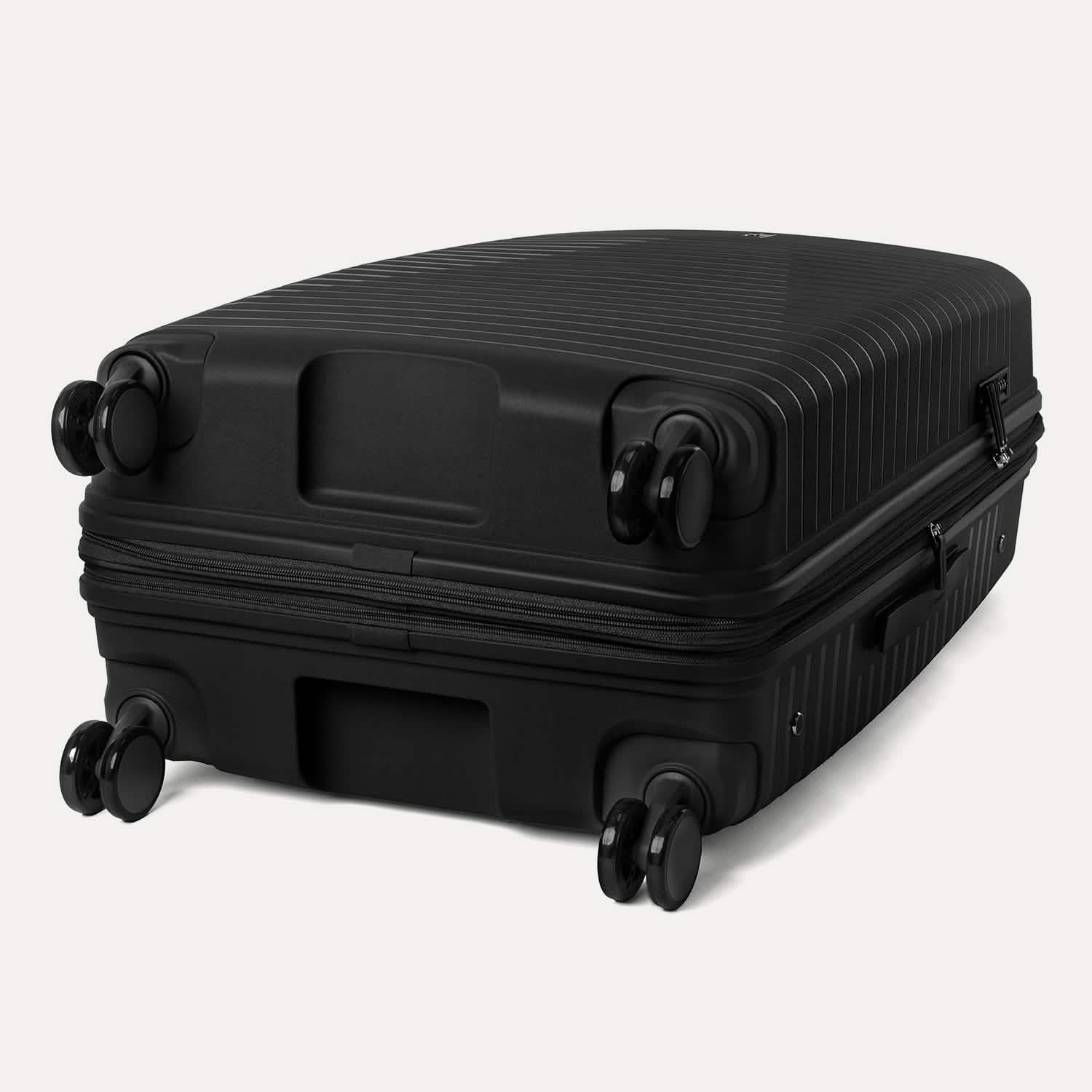 Valise noire à roulettes sur fond gris clair