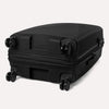 Valise noire à roulettes sur fond gris clair