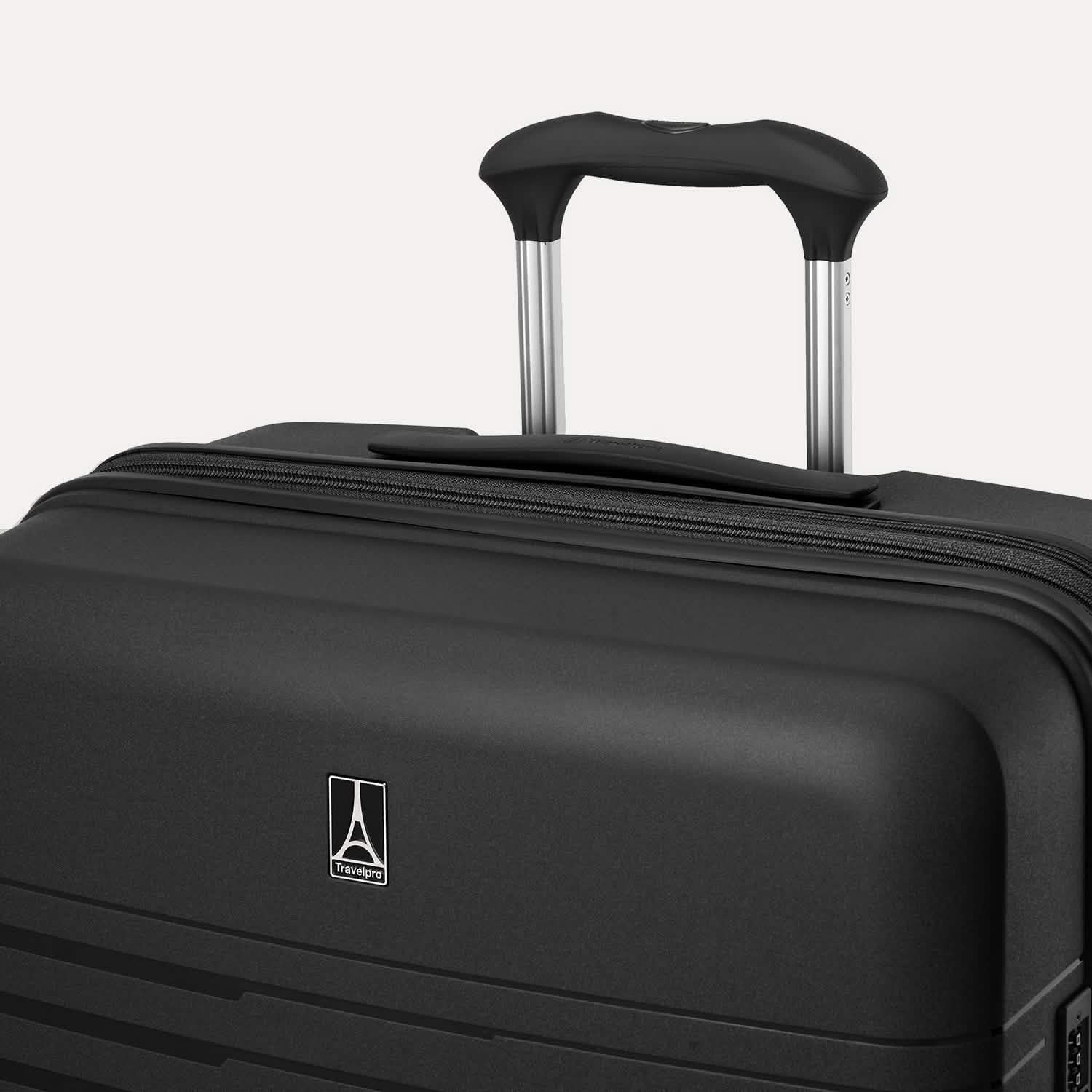 Valise noire avec le logo de la marque bien visible sur un fond gris clair