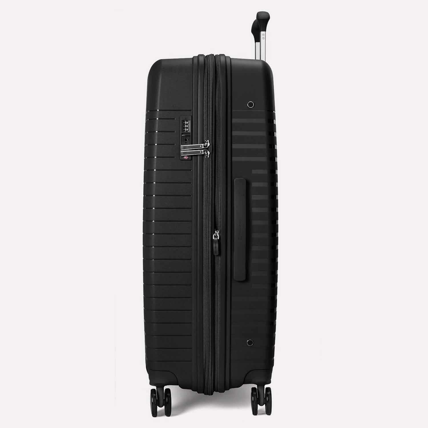Valise noire à roulettes sur fond gris clair