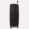 Valise noire à roulettes sur fond gris clair